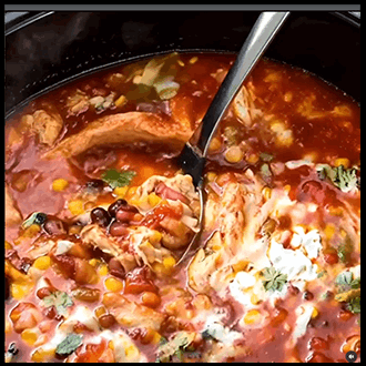 Bowl of chicken taco soup with cheese and avocado