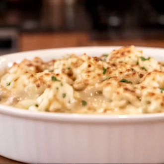 Baked seafood casserole with a golden-brown breadcrumb crust served in a ceramic baking dish.